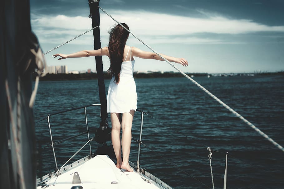 woman standing at the edge of a boat that is sailing in ocean, woman standing on boat edge while open arms, HD wallpaper