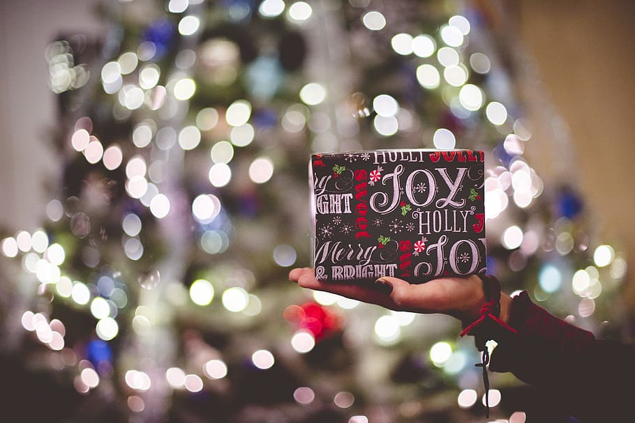 selective focus photography of gift box on person's palm, green and red box HD wallpaper