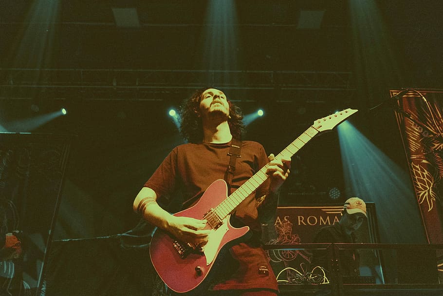 man holding red electric guitar, man holding electric guitar in stage HD wallpaper