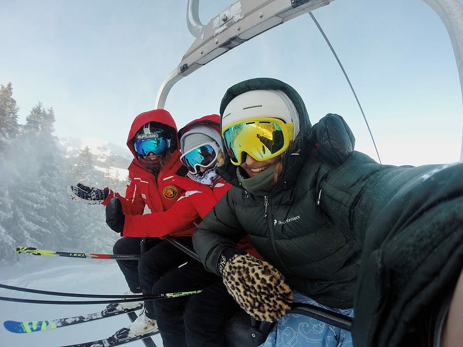 three person wearing ski gear riding cable car, three people riding ski lift HD wallpaper