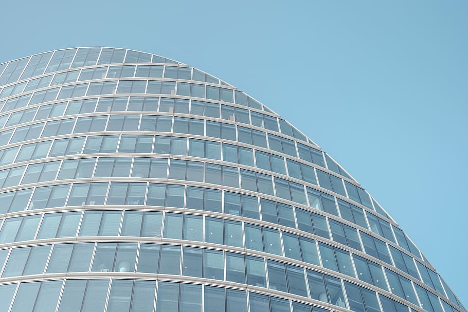 architectural photography of glass building, worm's-eye view of blue high-rise building under clear blue sky HD wallpaper