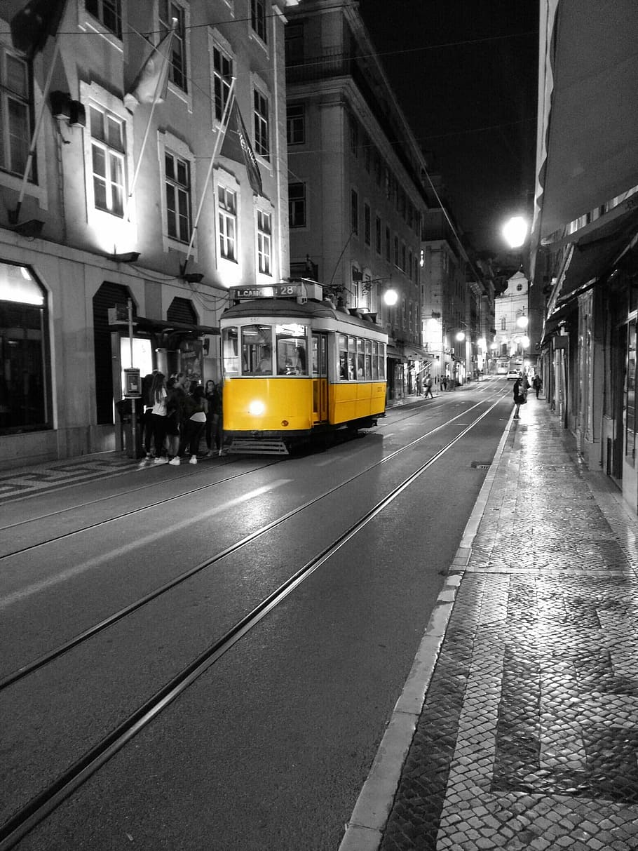 selective color photograph yellow and white tram, portugal, lisbon