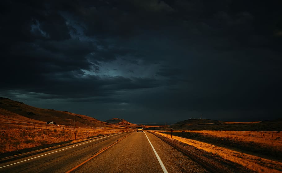 photo of road towards mountain, vehicle on gray concrete road under black sky HD wallpaper