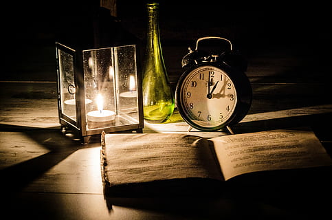 candle lantern and round white and black clock on top of table HD wallpaper