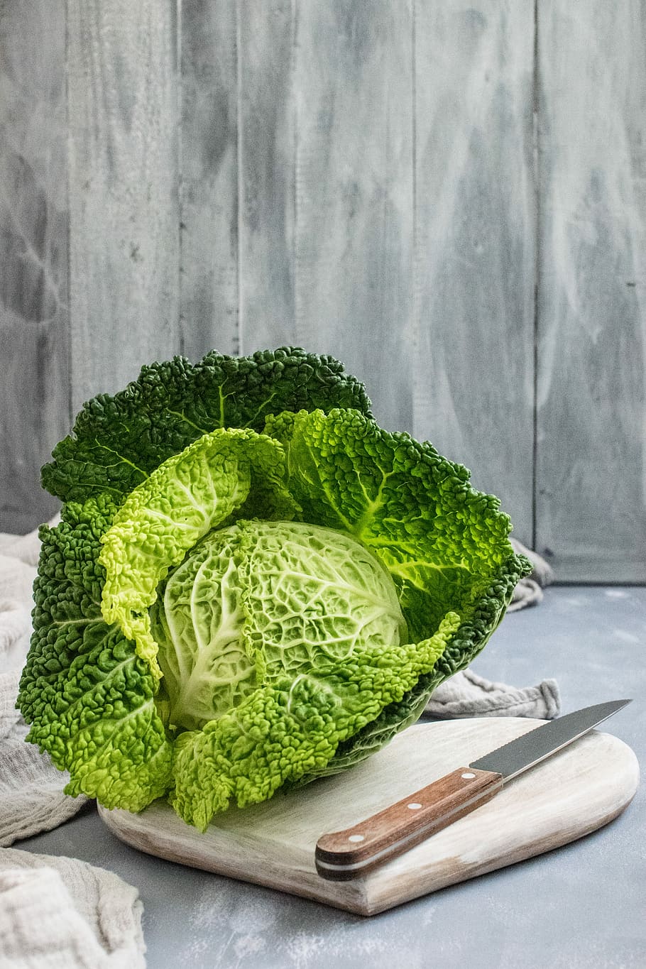 green cabbage on brown wooden chopping board, green cabbage and knife on chopping board HD wallpaper