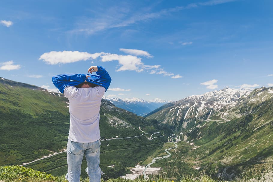 man standing in front of the mountain, person standing on mountain while changing clothe, HD wallpaper