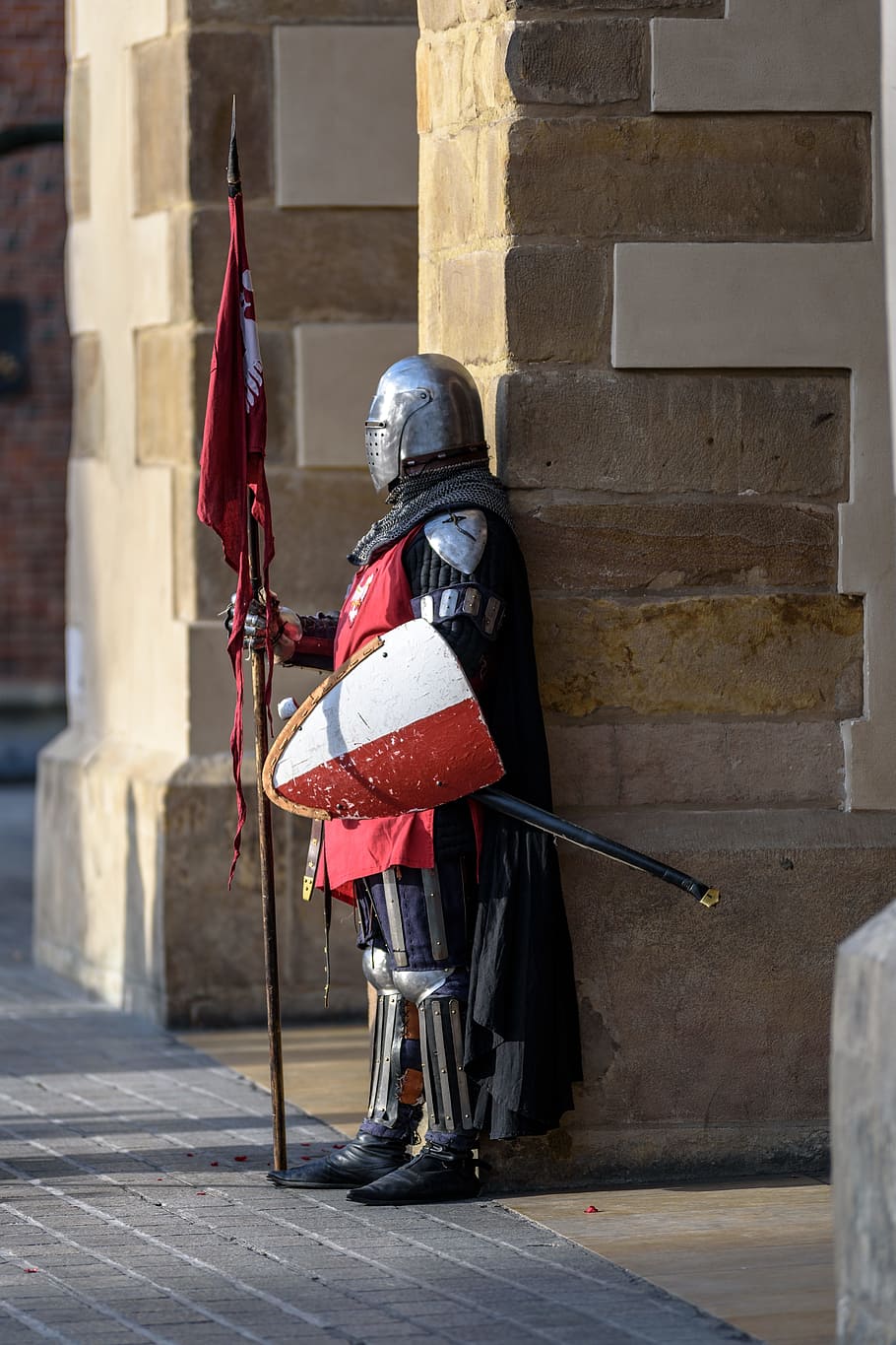 knight with shield holding flag standing near brown wall during daytime HD wallpaper