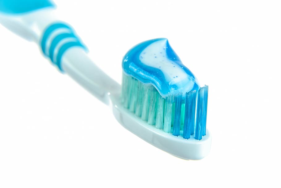 white and blue toothbrush with white and blue toothpaste, the background