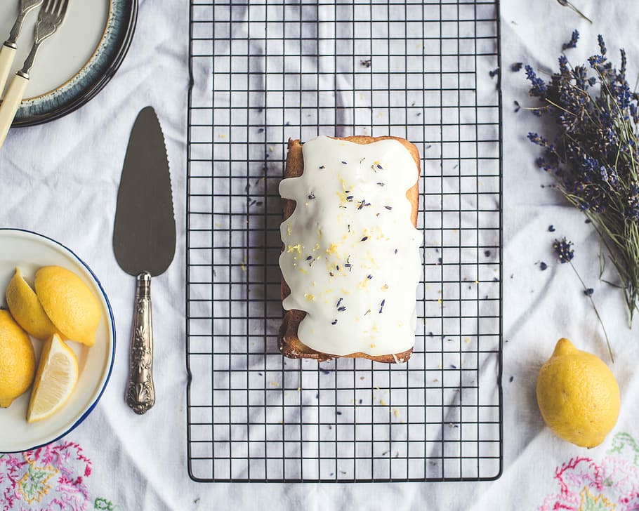 pastry with cream top, flat-lay photography of sweet pastry beside cake knife and lemon HD wallpaper