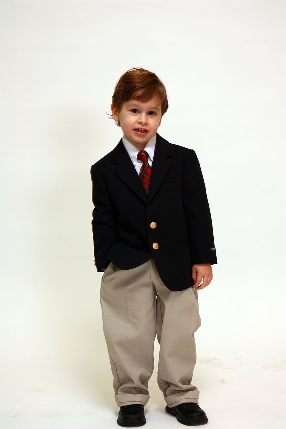 boy in suit jacket standing near white wall, portrait, formal