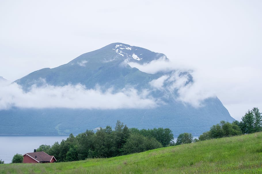 green mountain photo during daytime, barn near sea under white sky HD wallpaper