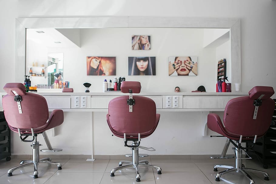 beauty saloon, three pink salon chairs in front of large mirror