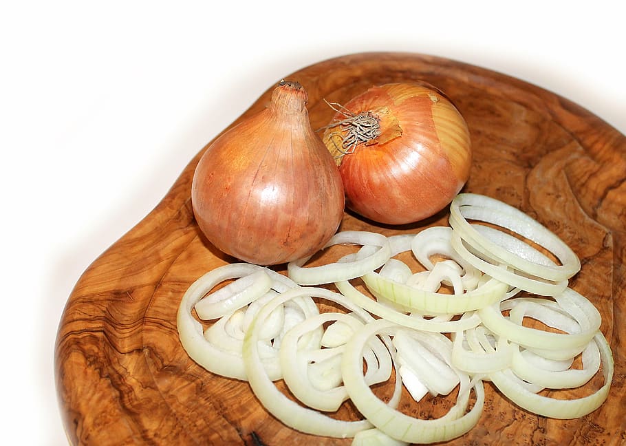 close-up photo of white onion bulbs on chopping boar, cutting board