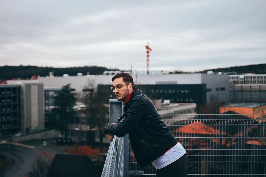 man standing besides railings, man leaning on gray metal rail HD wallpaper