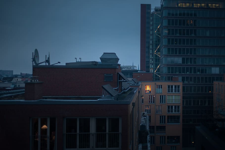 high rise buildings under gray clouds at nighttime, buildings under dark sky HD wallpaper