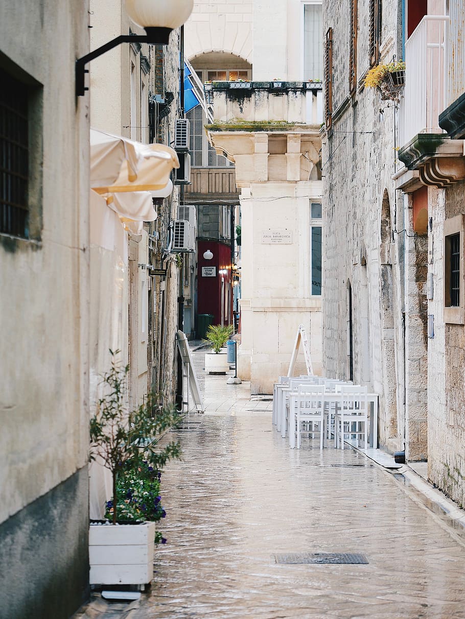 white tables and chairs near wall, pathway between buildings, HD wallpaper