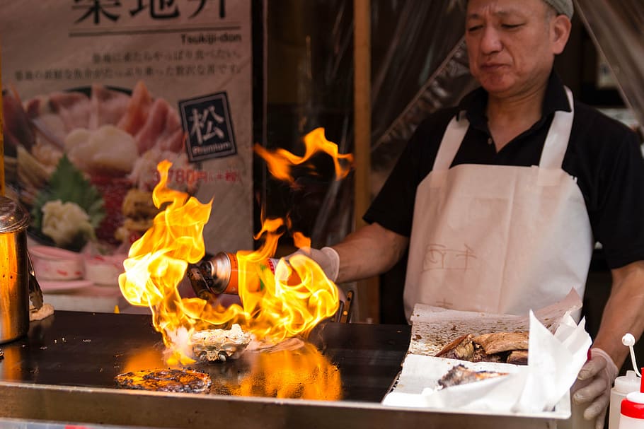 man cooking food at griddle, fire, chef, burning, front view HD wallpaper