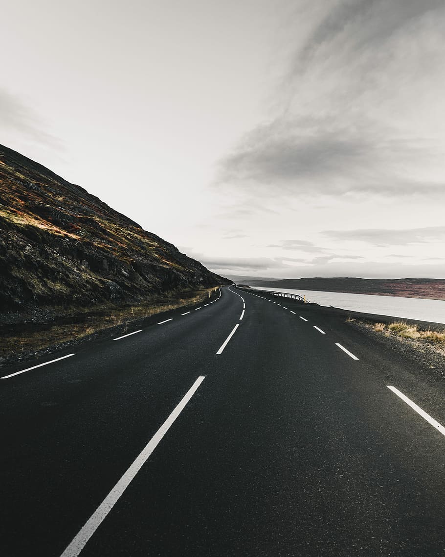 empty road between mountain and body of water, road beside hill and body of water during daytime, HD wallpaper