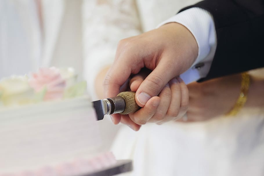 man and woman slicing cake, bride and groom cutting together a wedding cake HD wallpaper