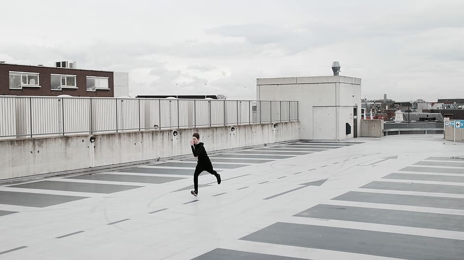 person running on concrete lot during daytime, man running on rooftop, HD wallpaper