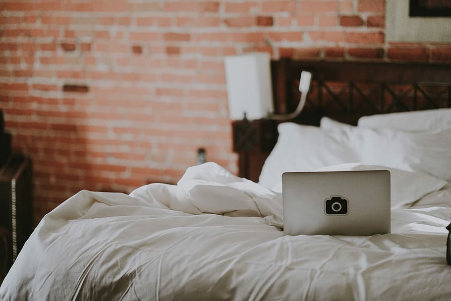 Laptop on bed, laptop on bed sheet, wall, pillow, brick wall HD wallpaper