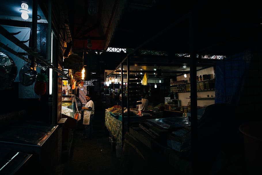 man in white shirt standing beside bdesk, man standing in front of store HD wallpaper