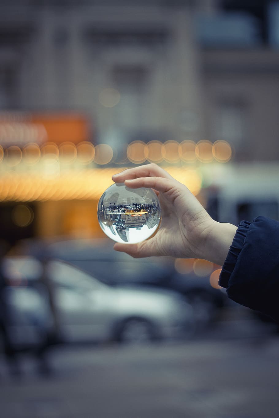 Sphere, selective focus photography of person holding baoding ball refracting buildings HD wallpaper