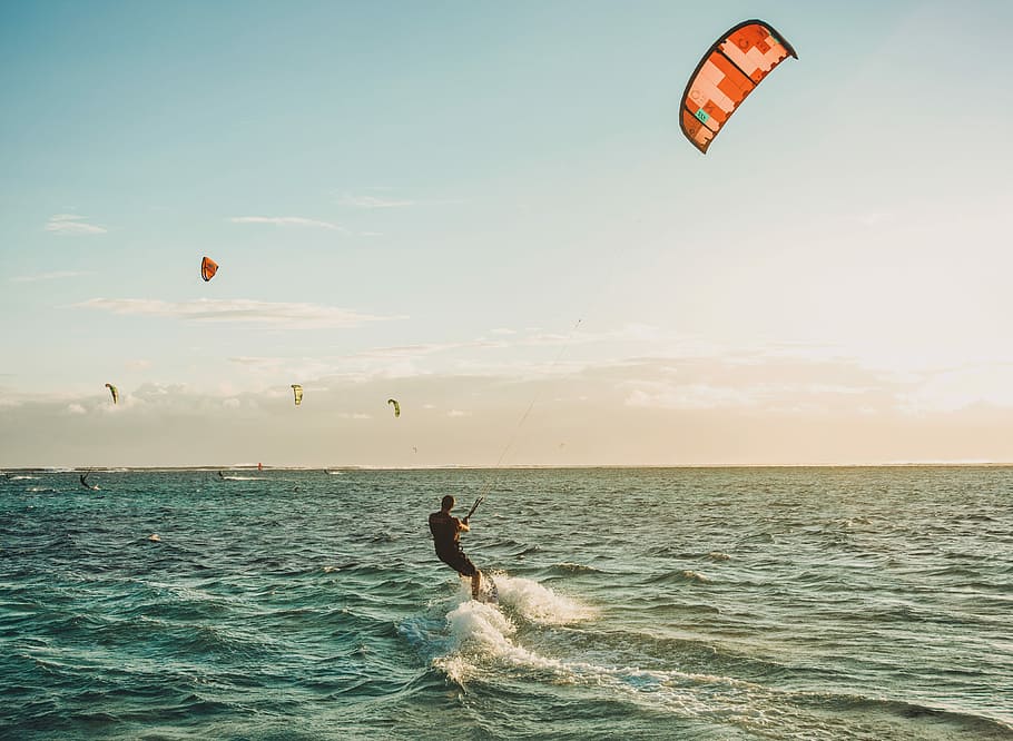 person parasailing on body of water under blue sky during daytime, man parasurfer during daytime HD wallpaper