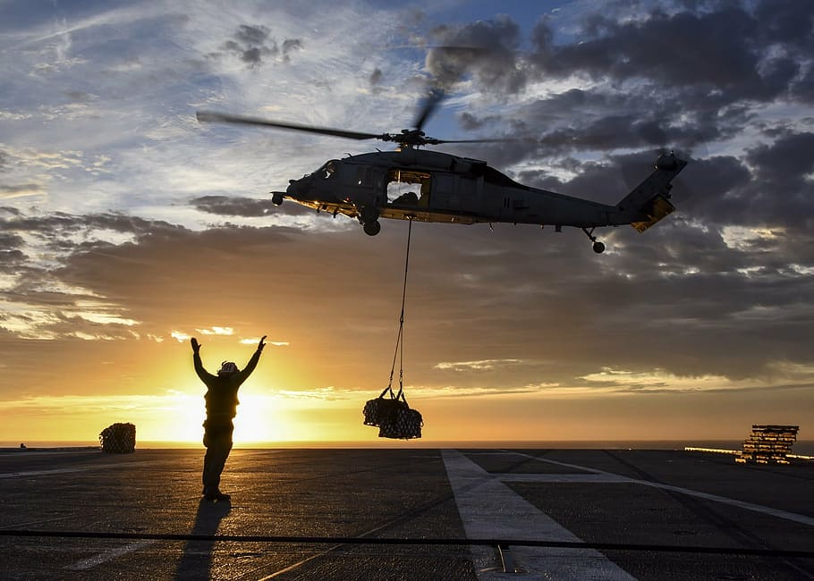 person waving his hand during daytime, helicopter, sunrise, sea hawk