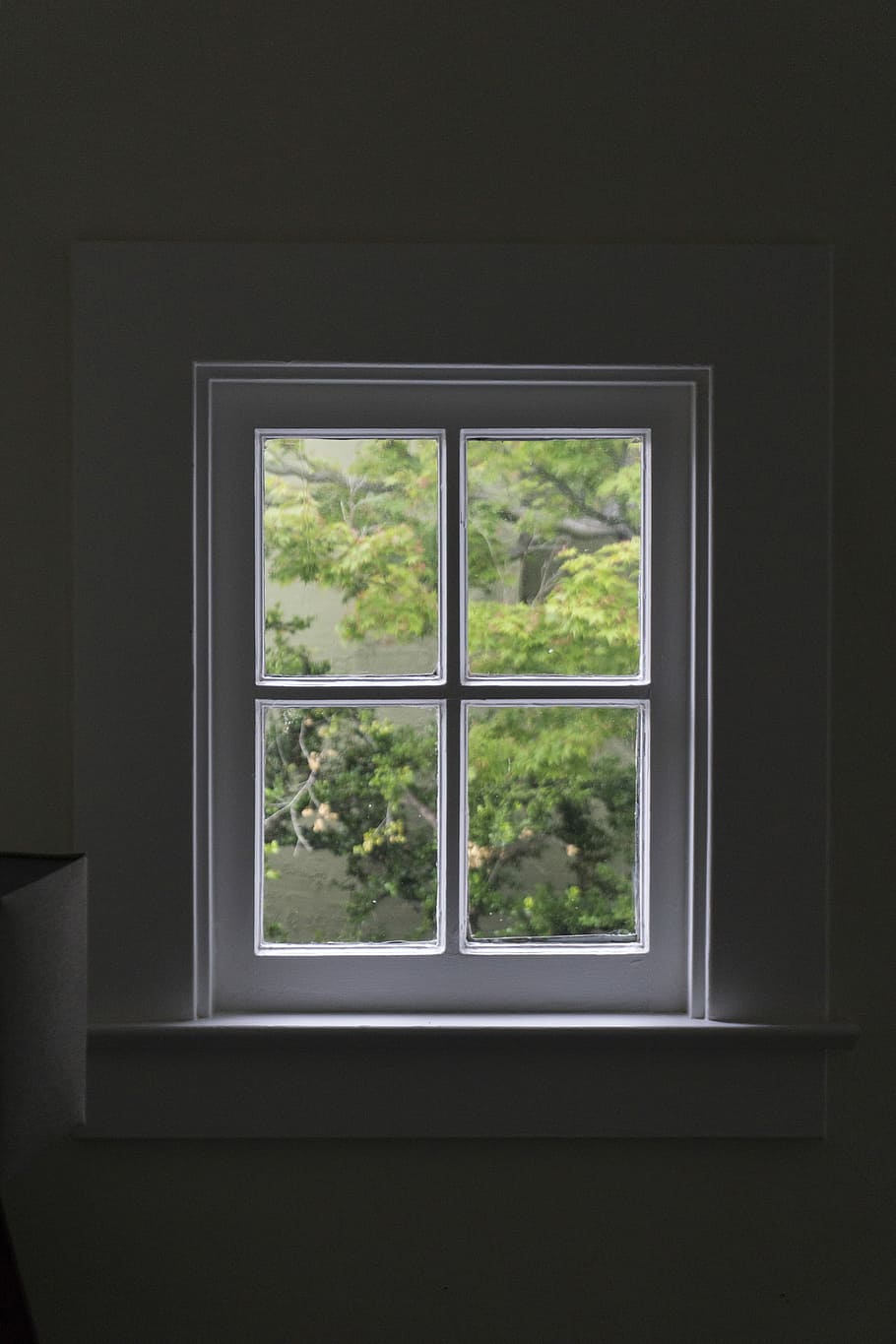 gray wooden windowpane, white wooden 4-pane window inside dark room