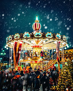 carousel with snow pouring down, people surrounding carousel HD wallpaper
