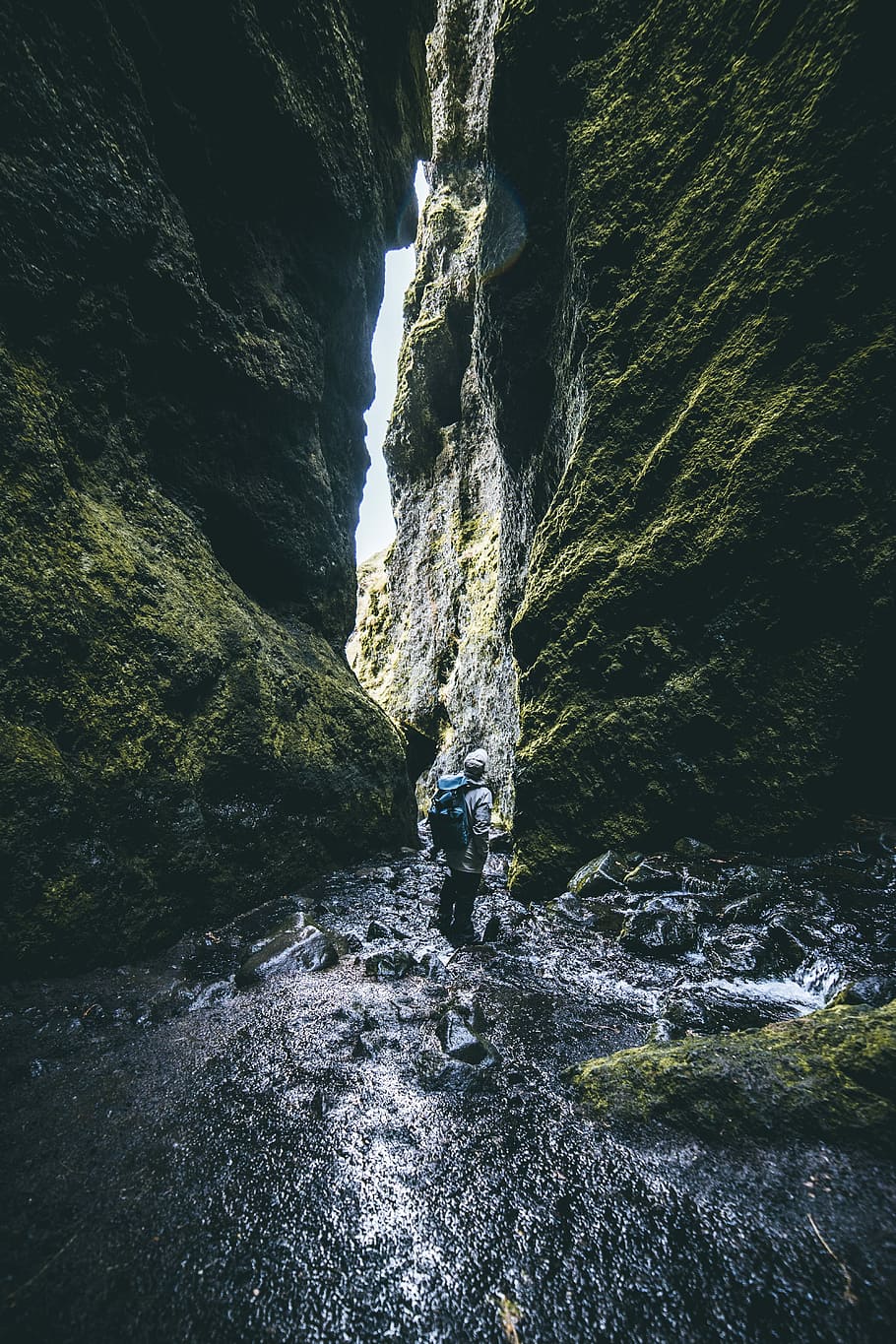 man standing in between of rock formations, man standing on river water while looking up HD wallpaper