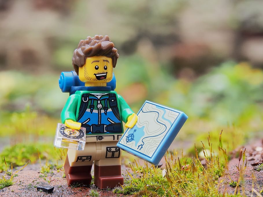 shallow focus photography of hiker LEGO plastic toy, walker, rambler