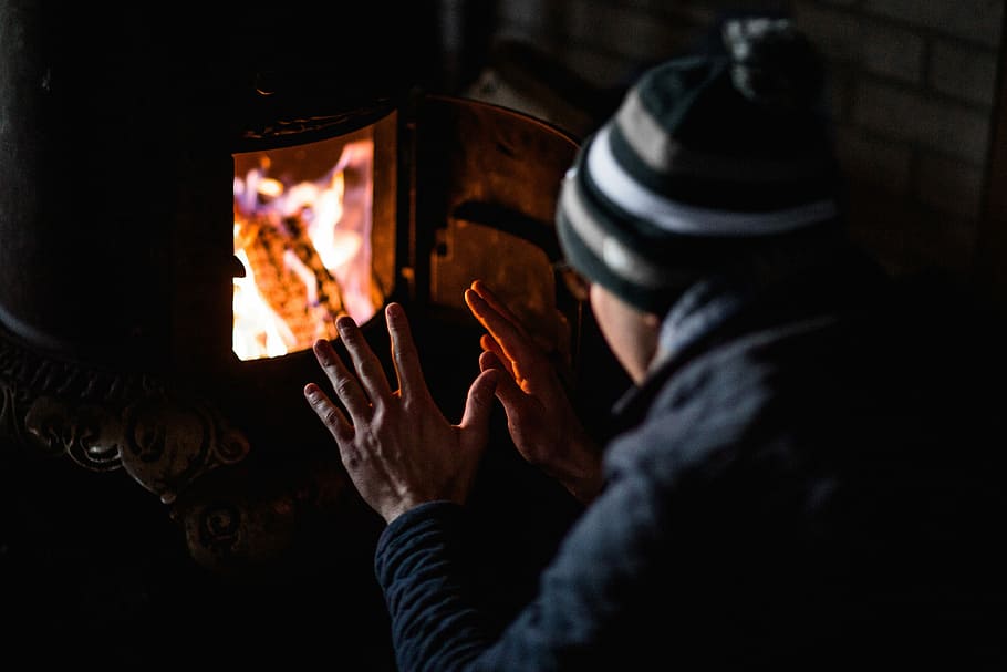 man in black jacket and green and white beanie in front of a furnace HD wallpaper
