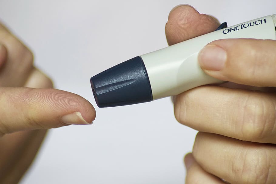 person holding blood pik device, diabetes, finger, glucose, test