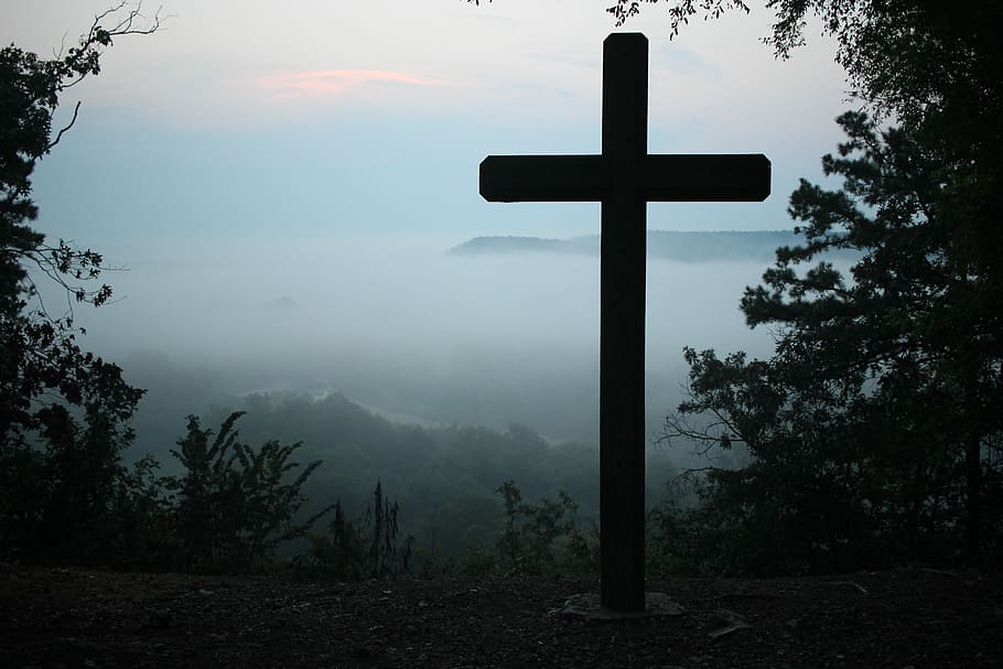 Cross Through The Clouds, brown cross statue surrounded by trees