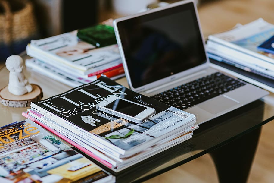 Laptop, a smartphone, magazines and cups of coffee on a table HD wallpaper