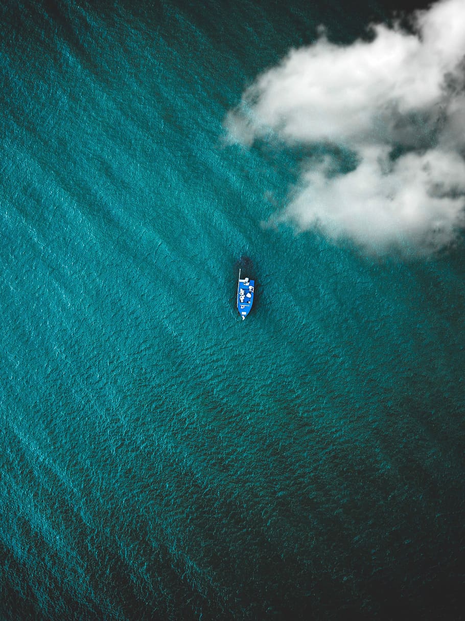 top view photo of boat on body of water, blue boat floating under white sky during daytime HD wallpaper