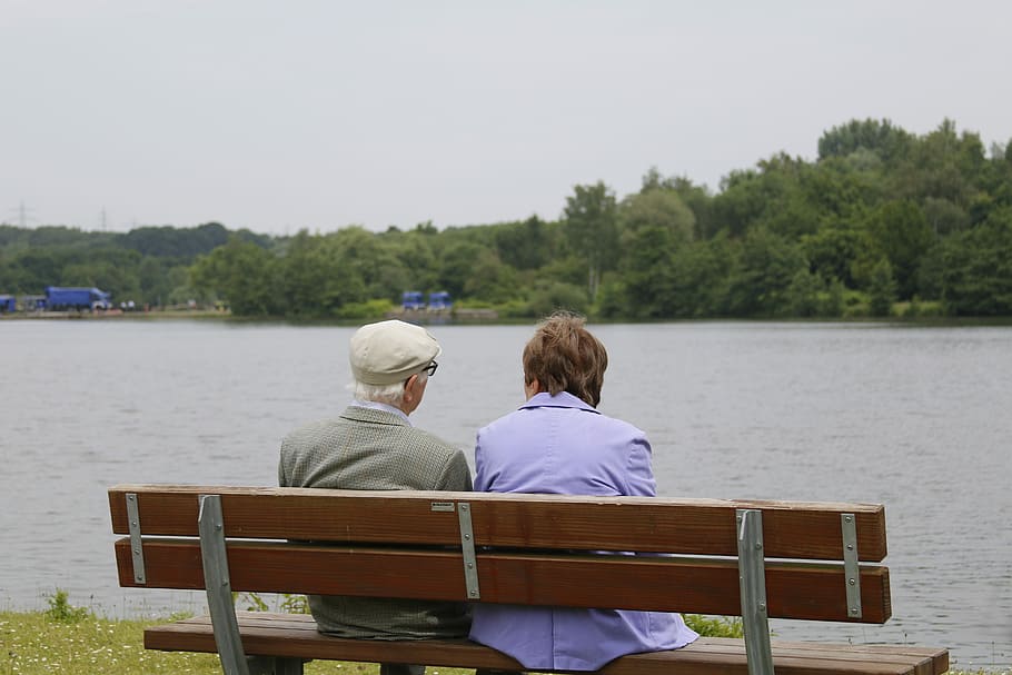 two person sitting on bench near river during day time, Peace