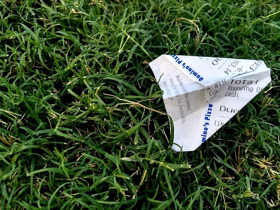 Receipt Folded Into Paper Plane on Grass, airplane, childhood