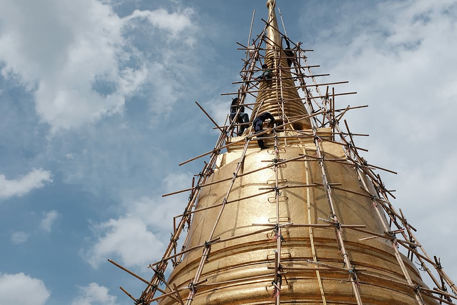 person building tower, low angle photography of people climbing gold structure at daytime HD wallpaper