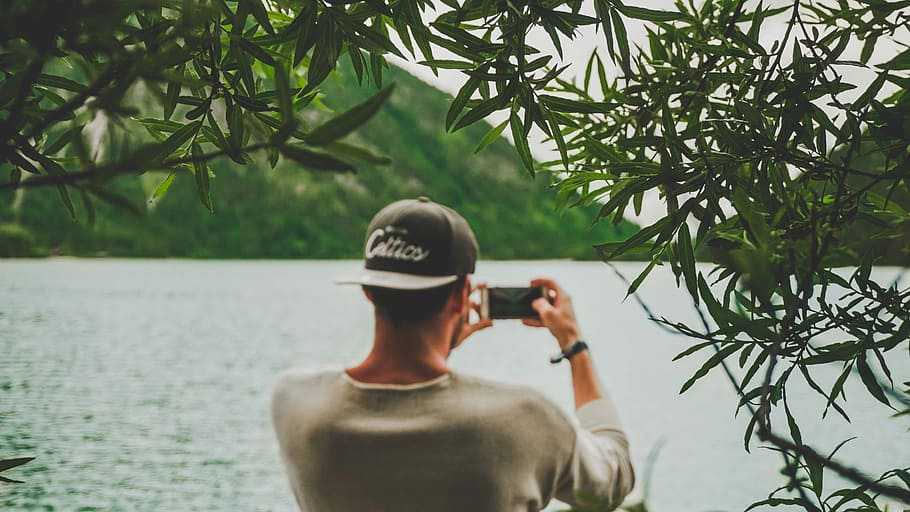 man taking photo of body of water using smartphone, landscape HD wallpaper