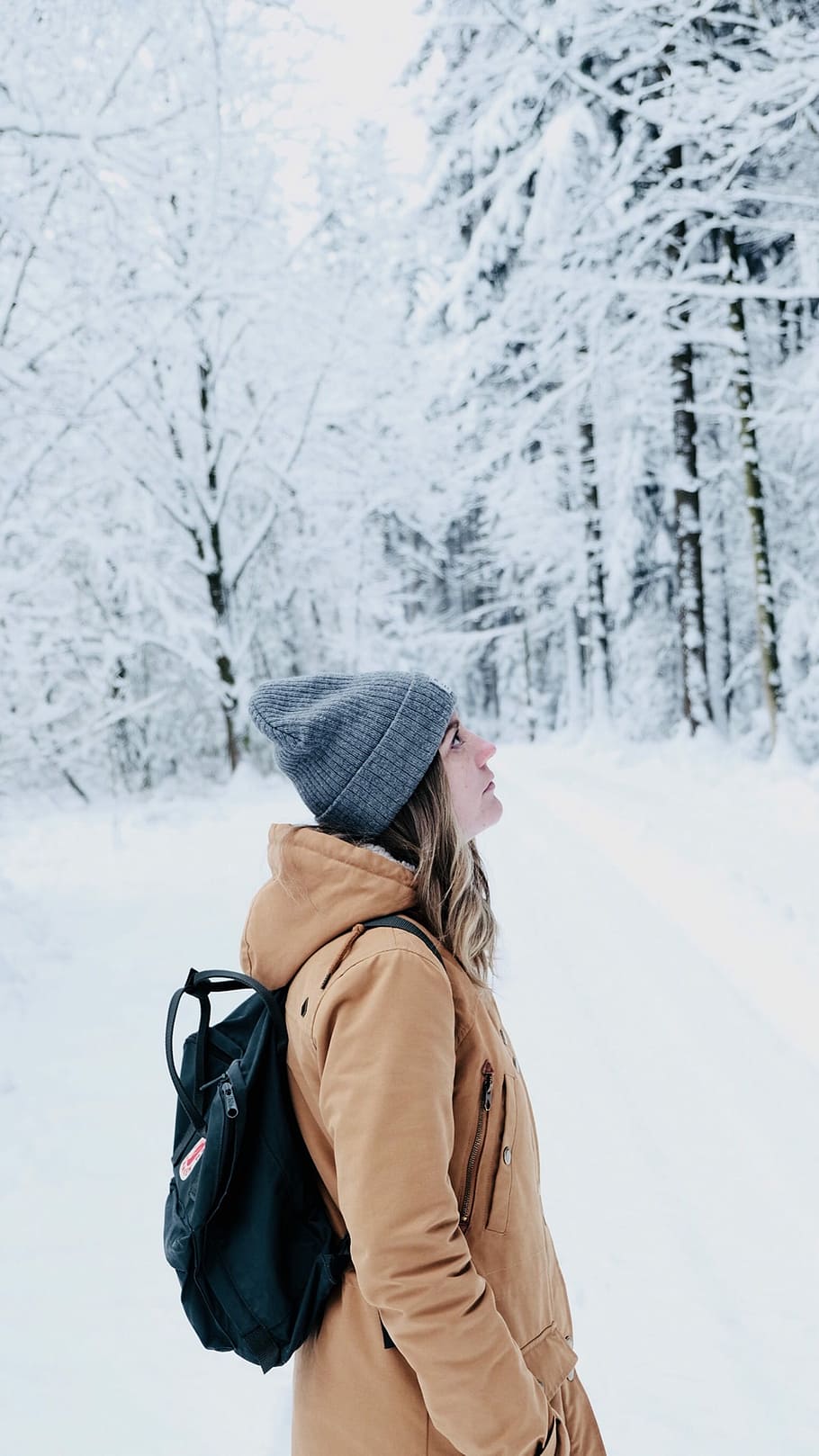 woman walking in snow covered forest, woman standing near snow covered trees during daytime HD wallpaper