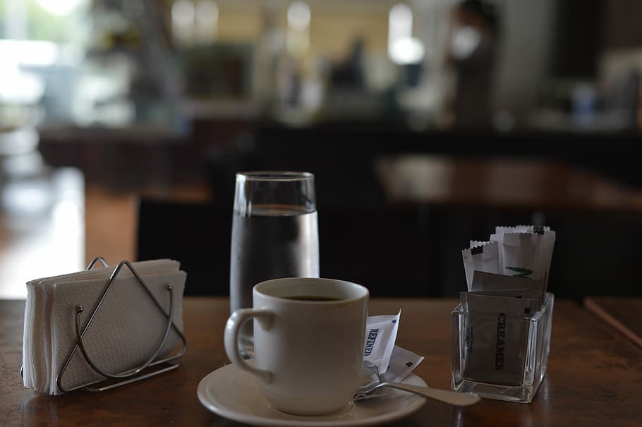 selective focus photography of teacup beside tissue and drinking glass on top of table, mug on saucer with coffee on table HD wallpaper