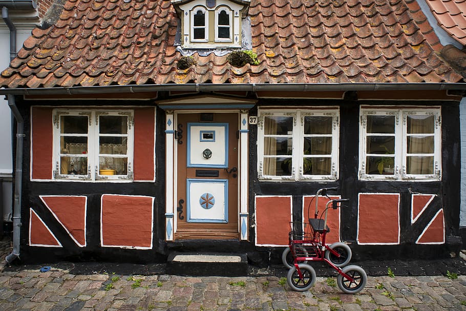 red rollator beside black concrete house during daytime, red rollator parked near brown and black house HD wallpaper
