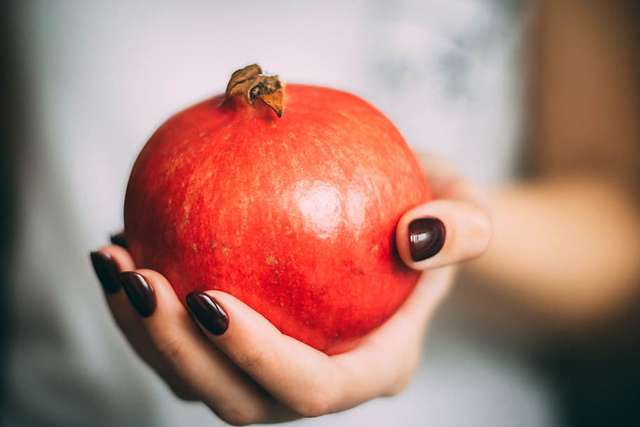 Red Pomegranate at Woman's Hand, blur, close-up, colors, fruit HD wallpaper