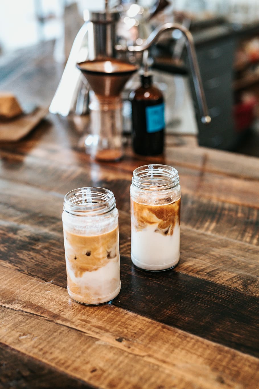 two clear glass jars on brown table, selective focus photography of two clear glass bottles on brown table HD wallpaper