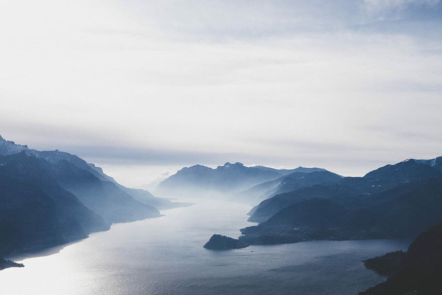 fog covered body of water, aerial view photography of body of water between mountain HD wallpaper