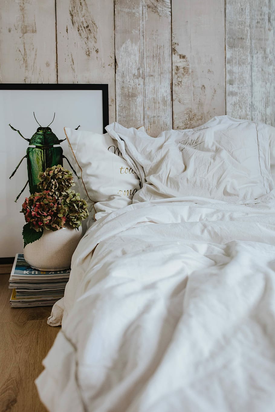 White bed sheets with a picture of a green beetle and a pot plant on a stack of magazines, HD wallpaper
