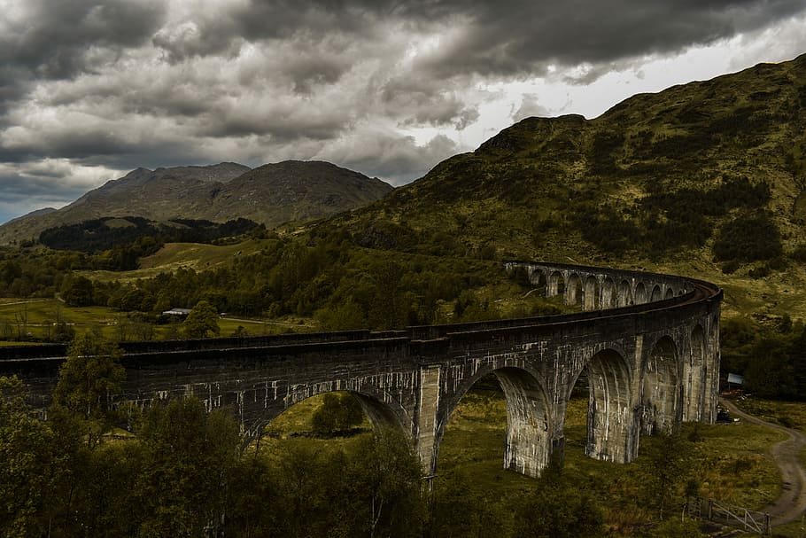 Glenfinnan Viaduct, concrete bridge surround by mountains and trees